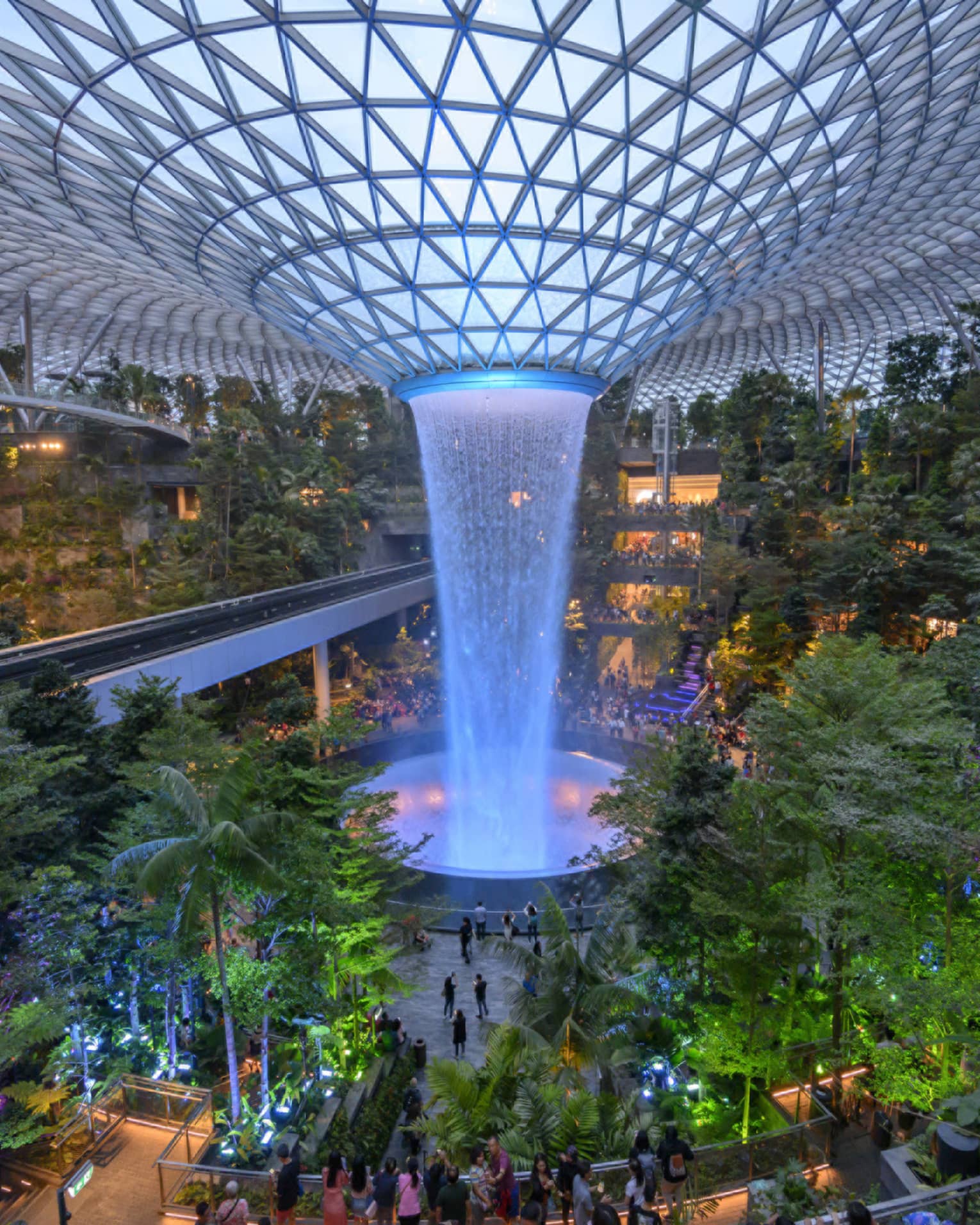 An arial view of an indoor garden with a large fountain in the center in singapore