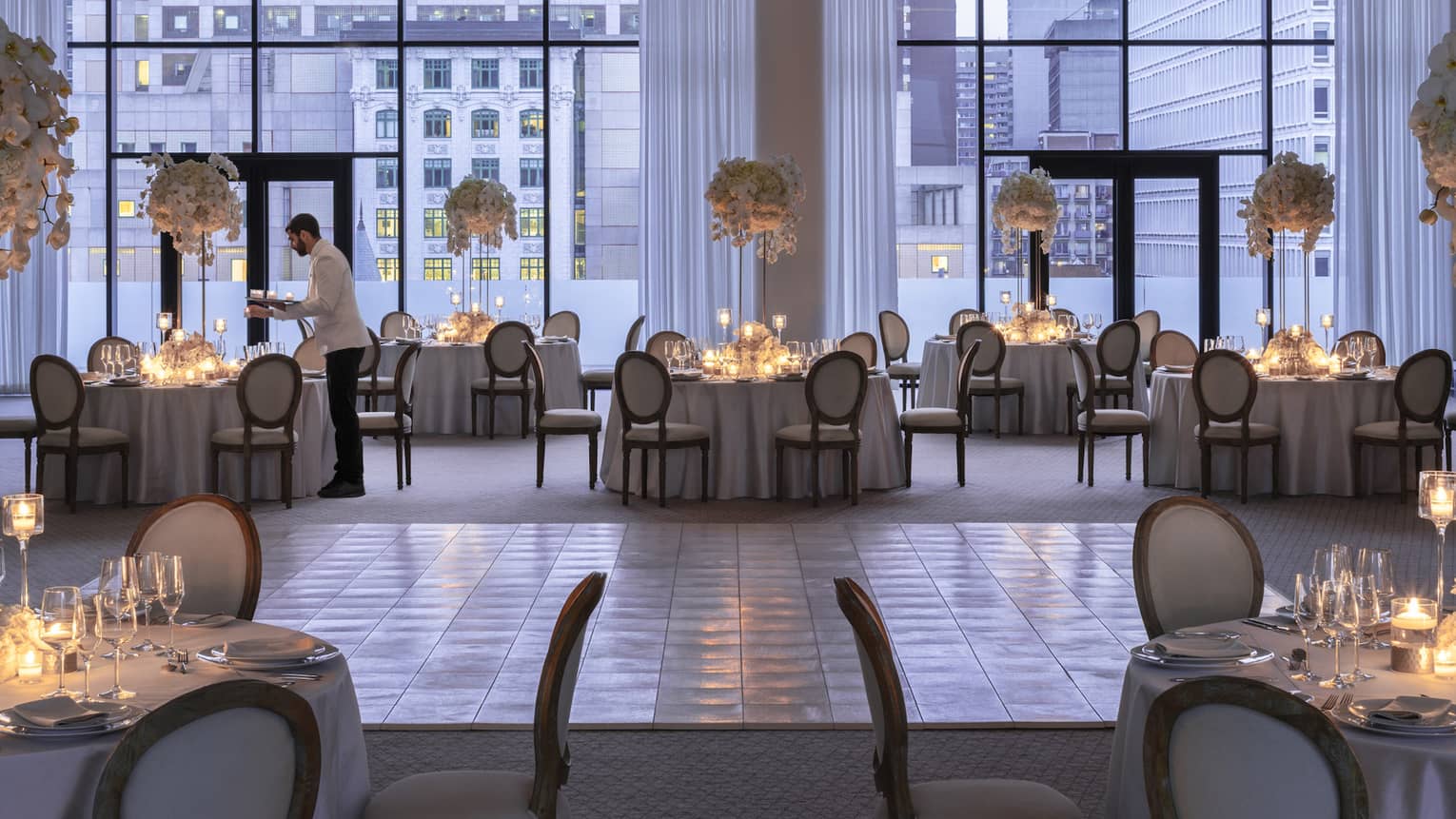 Four Seasons staff sets round table with candles in Palais des Possibles Ballroom