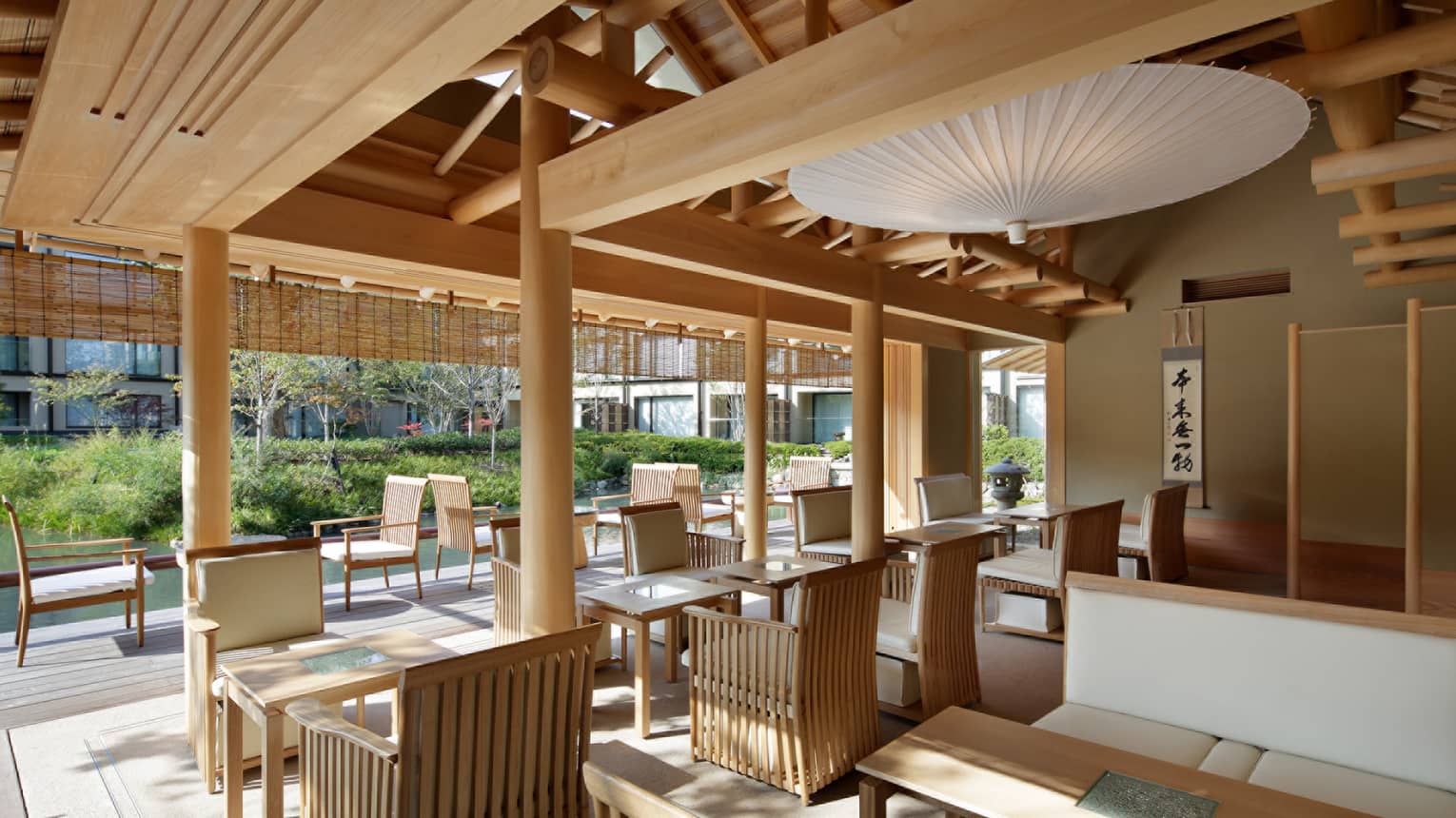 Shakusui-tei sunny patio with wood chairs, tables under white paper umbrella