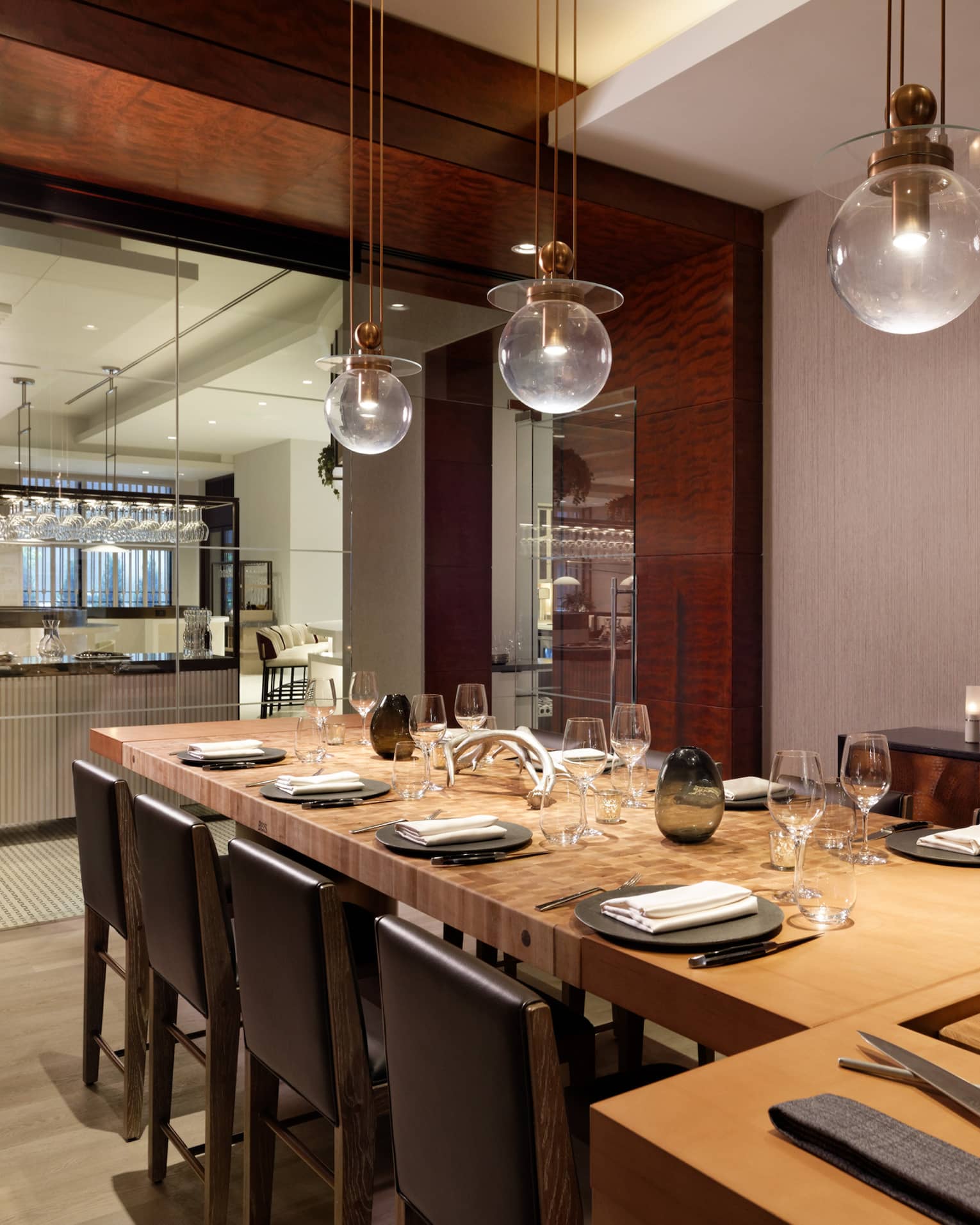 A large dining table with a carving station next to a clean open kitchen.