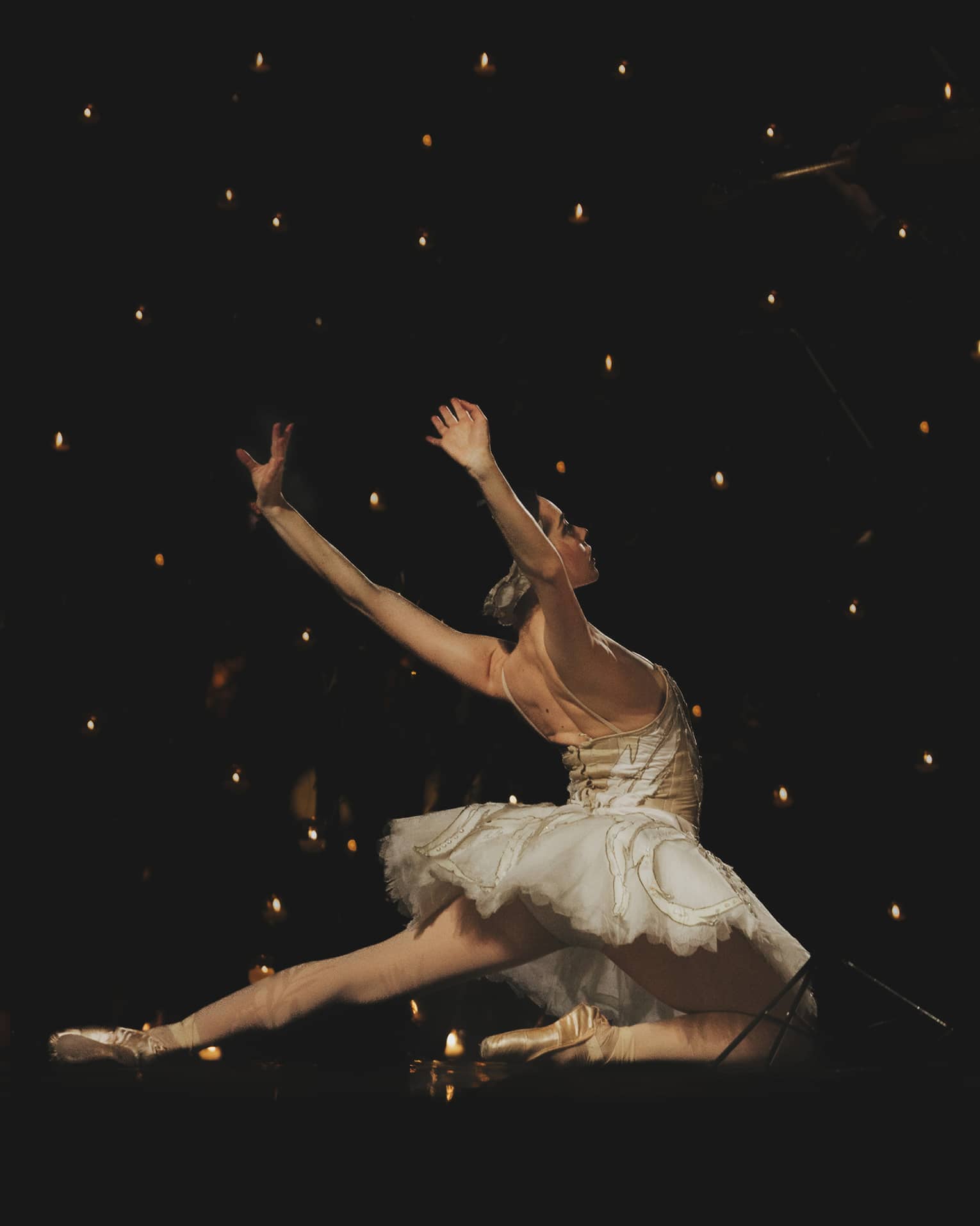 A ballerina dancing in front of a dark background.