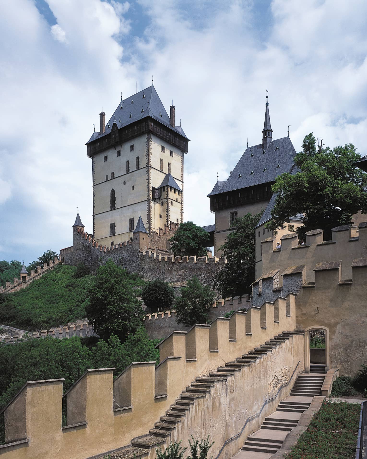 Looking up at historic Prague Karlstejn Castle towers, castle walls on sunny day