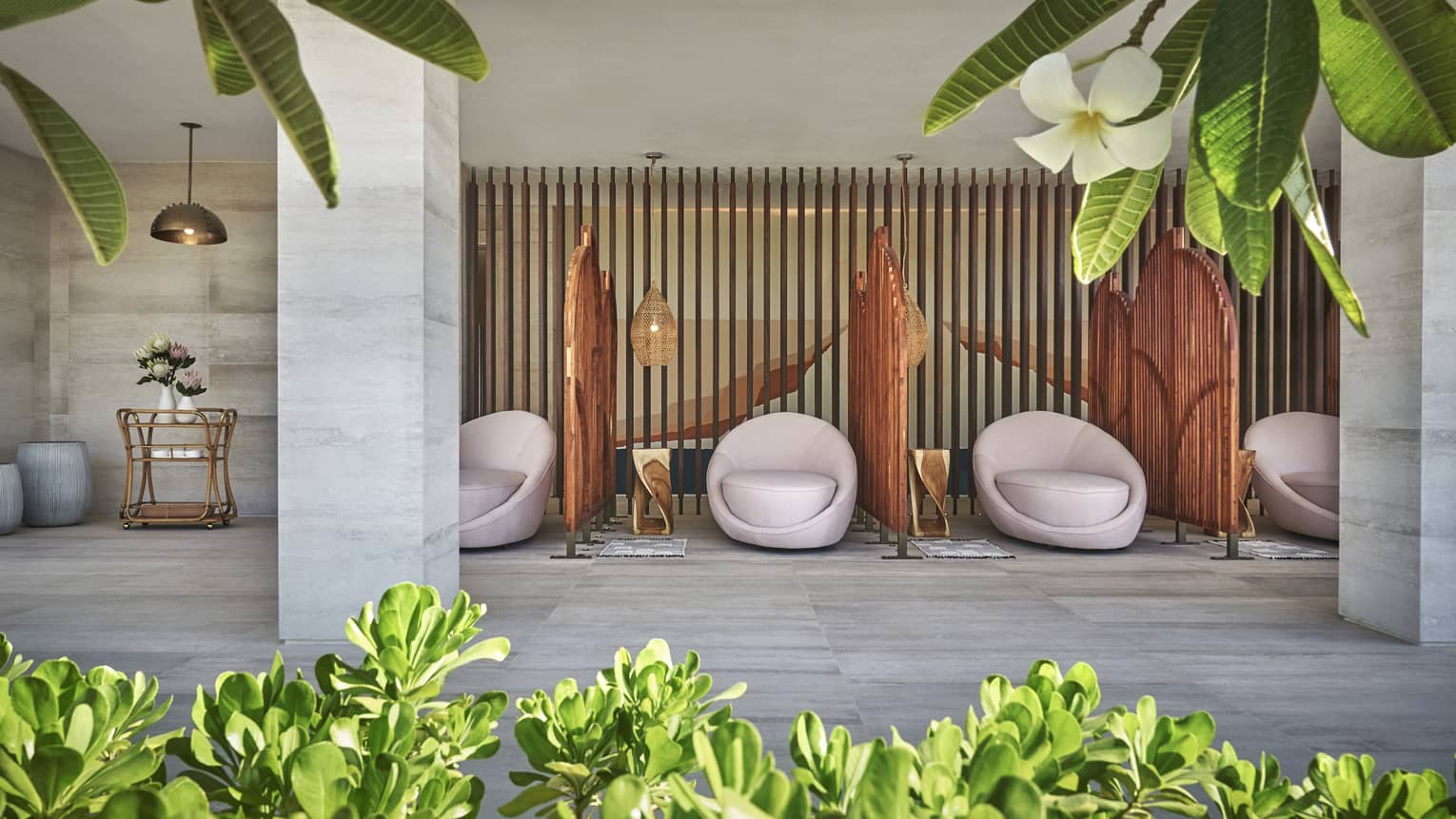 White egg-shaped spa chairs are separated by rattan walls in the four seasons resort los cabos spa terrace