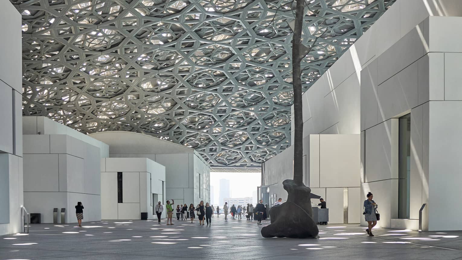 A large sculpture inside of a white stone building.