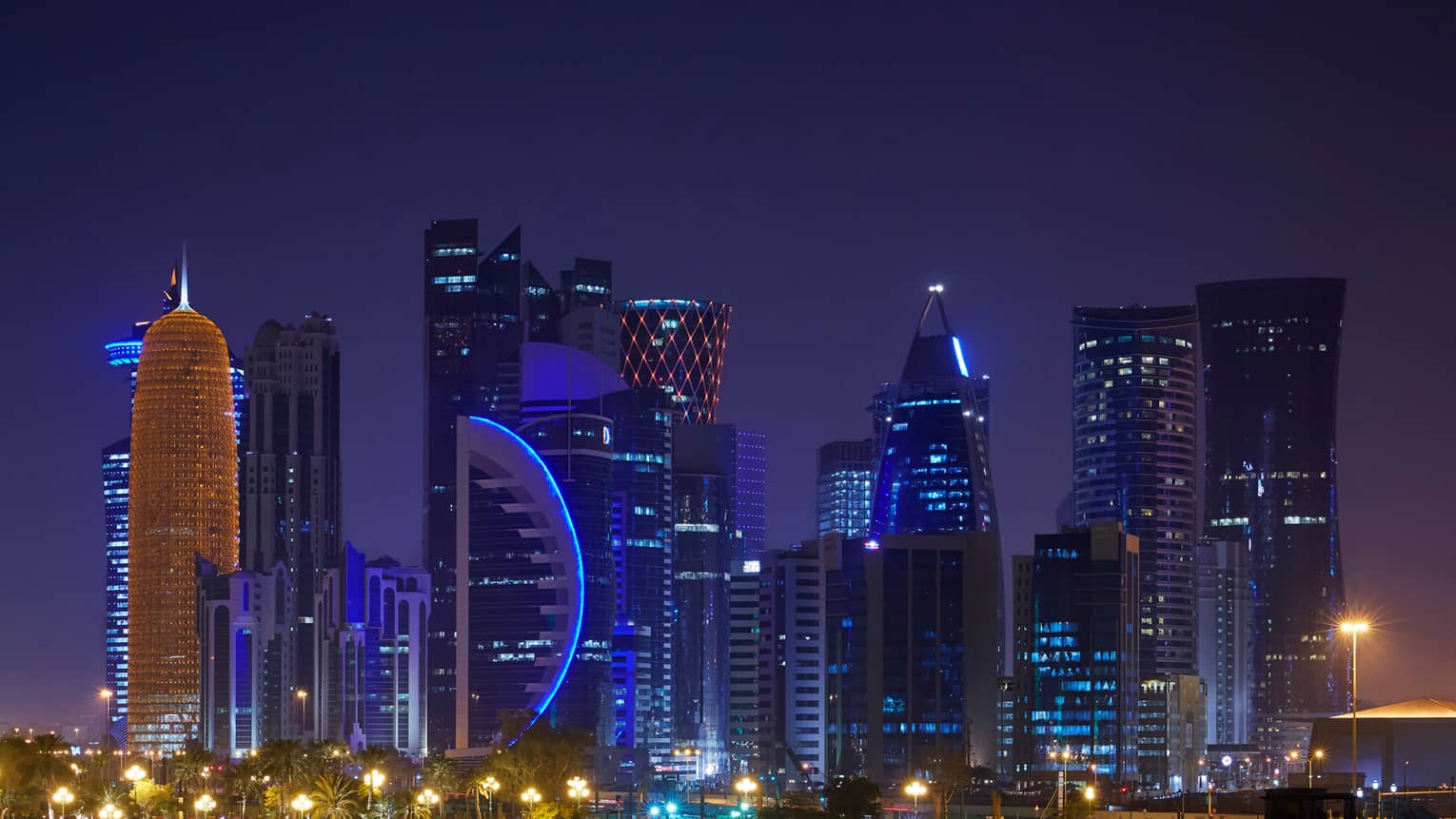 Doha skyline at night with blue lights, lit skyscraper windows