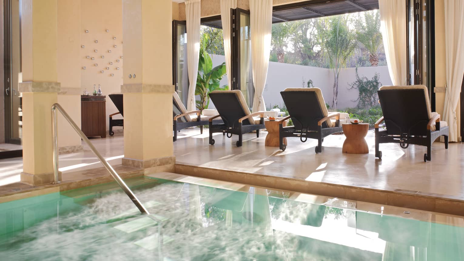 Three lounge chairs at sunny window by steps to Spa plunge pool