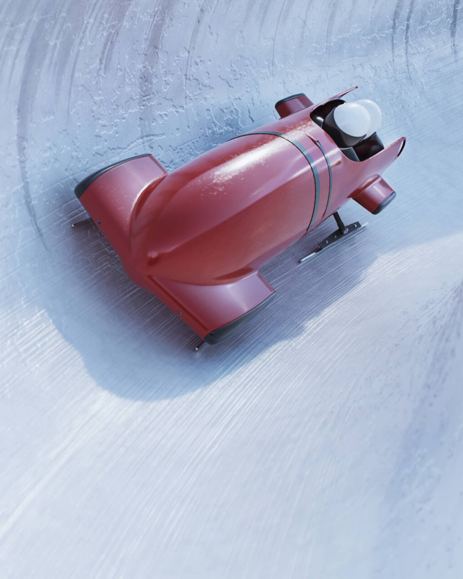 Front view of a bobsleigh zipping around a corner on a concave icy track, the helmets of two riders visible from the cockpit.