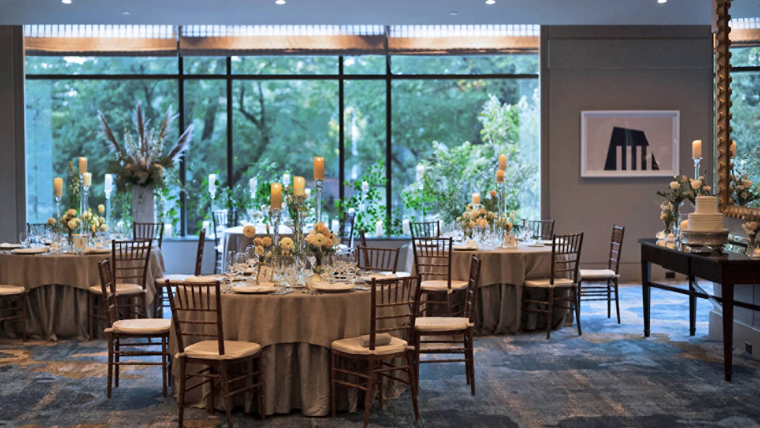 A room with dining tables and a large window on the back wall.