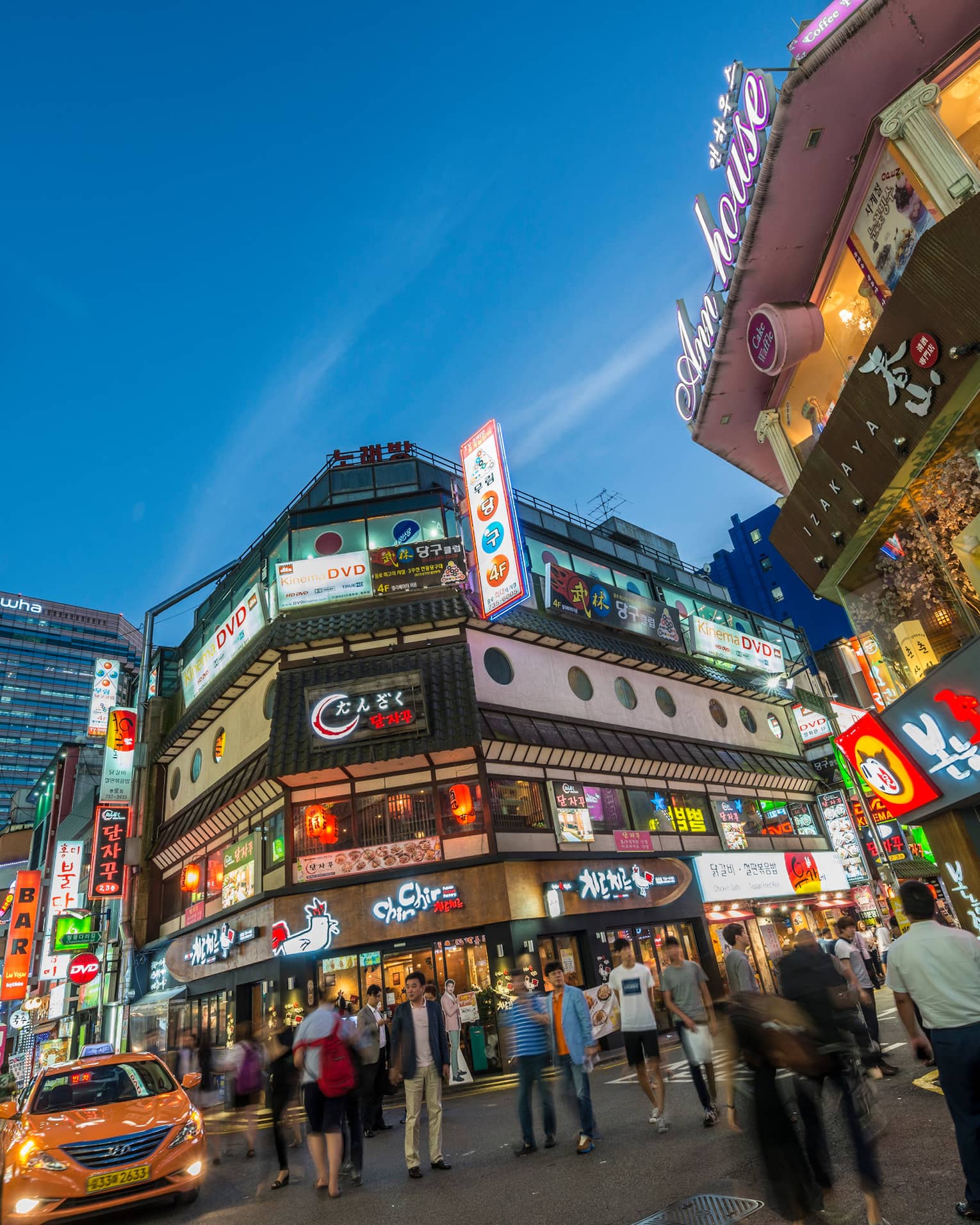 People gather under billboards, lights in Seoul city