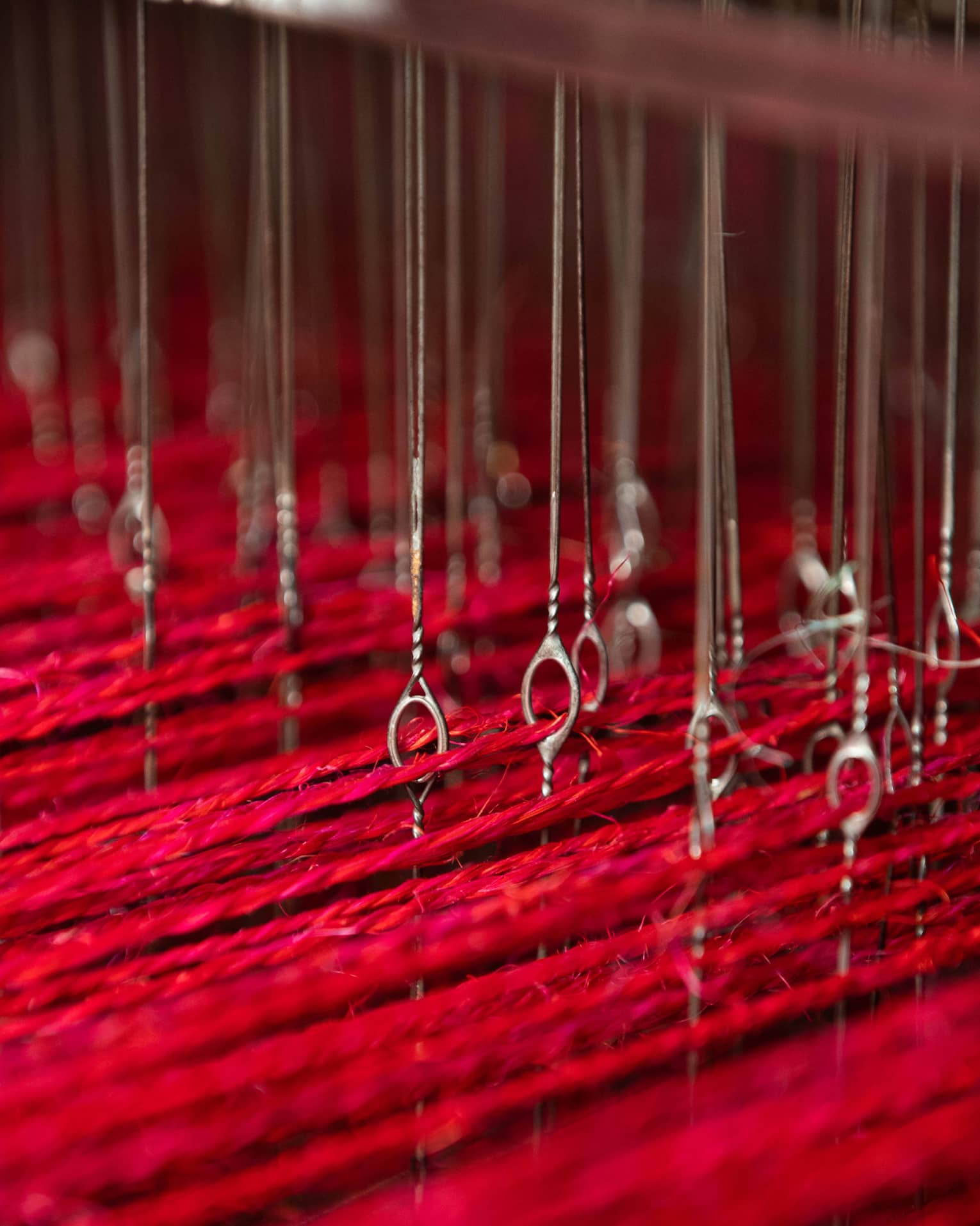 Long pieces of red string suspended by a series of wire.