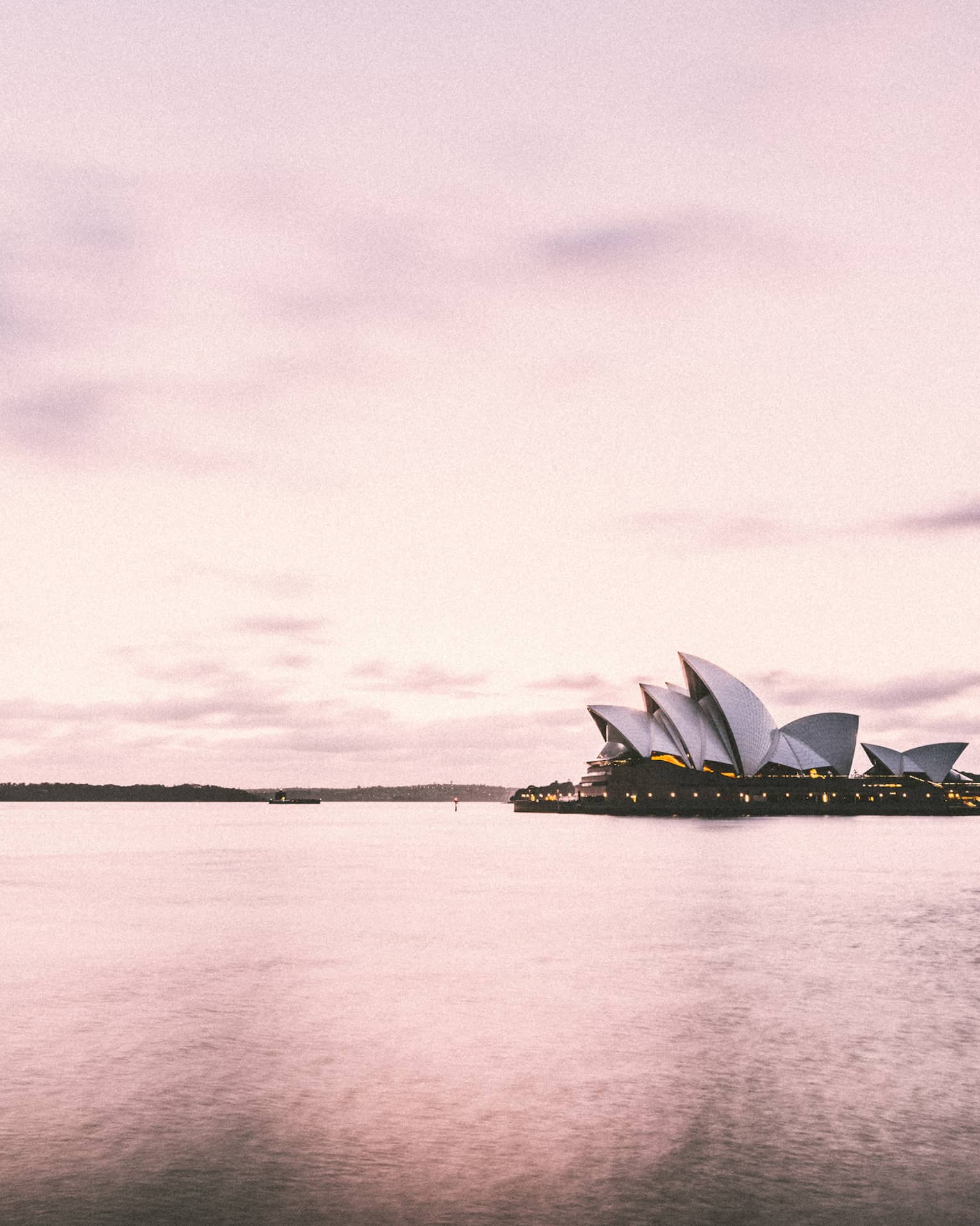 Sydney Harbour's iconic Opera House building on water, pink hue