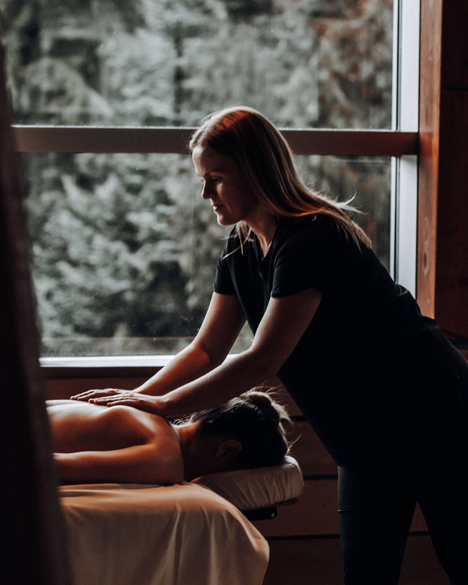 A woman receicing a massage in a dimly lit room.
