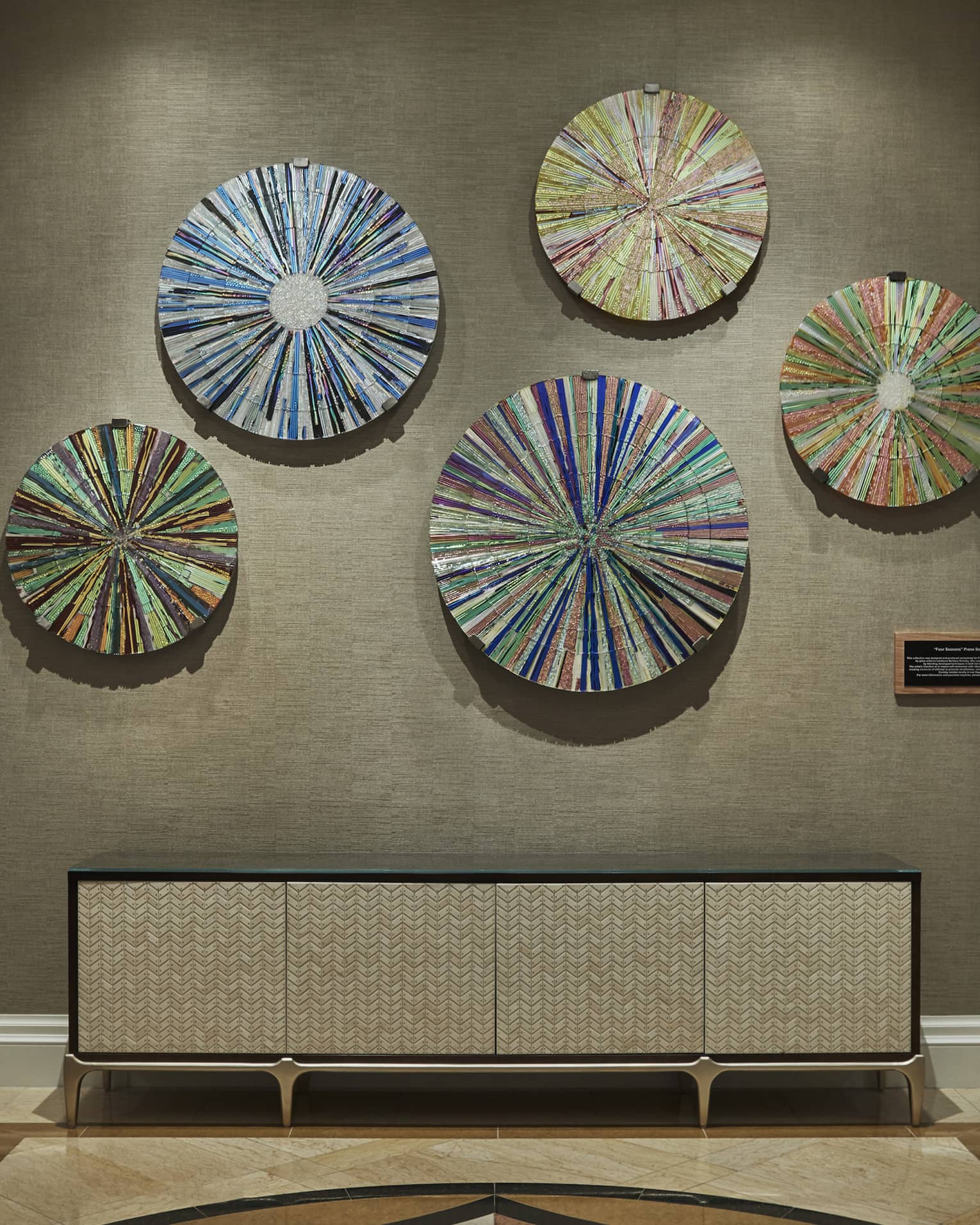 Spa wall with colourful disc art mounted on wall over console table