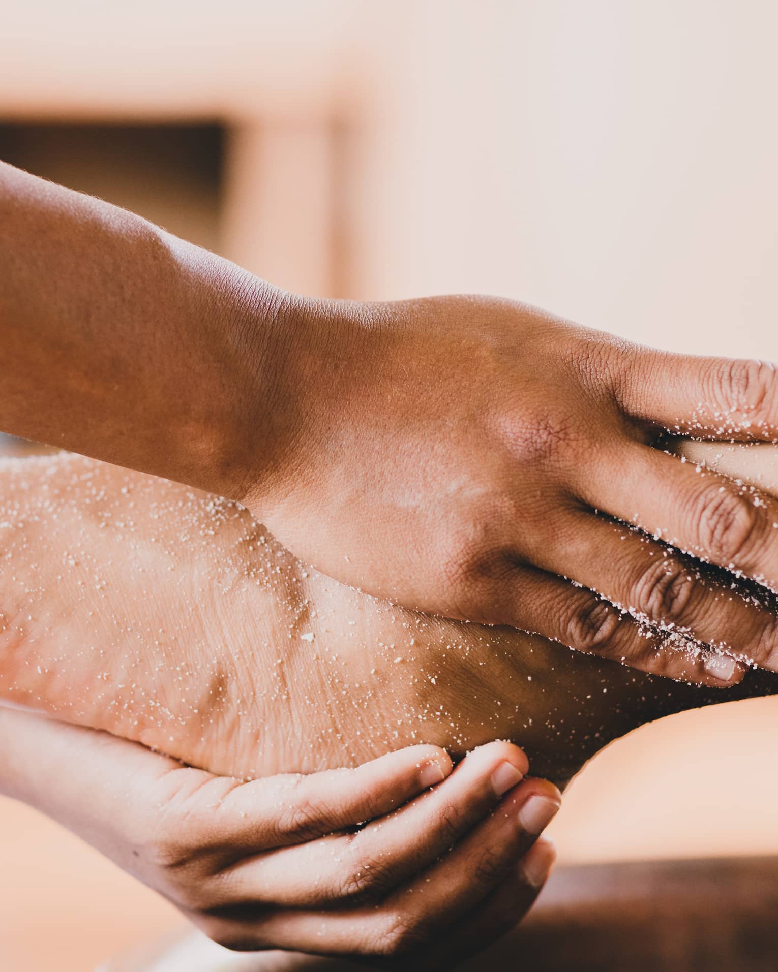 Hands hold a person's foot and ankle in a spa