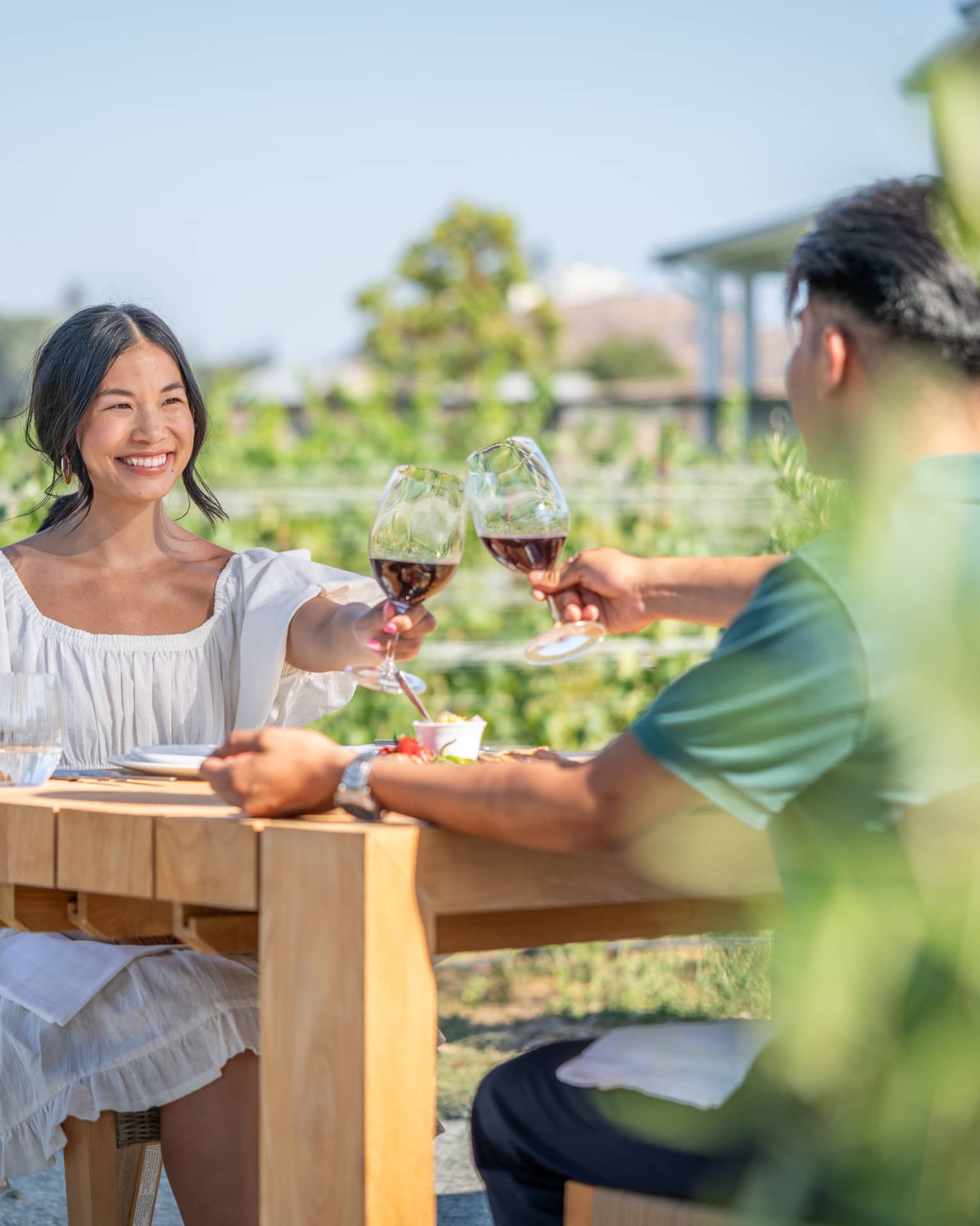 A man and woman enjoying wine outside.