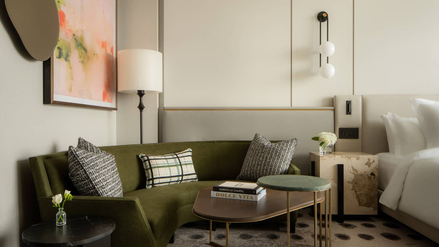 Hotel suite bedroom with dark green corner sofa at Four Seasons Hotel Toronto