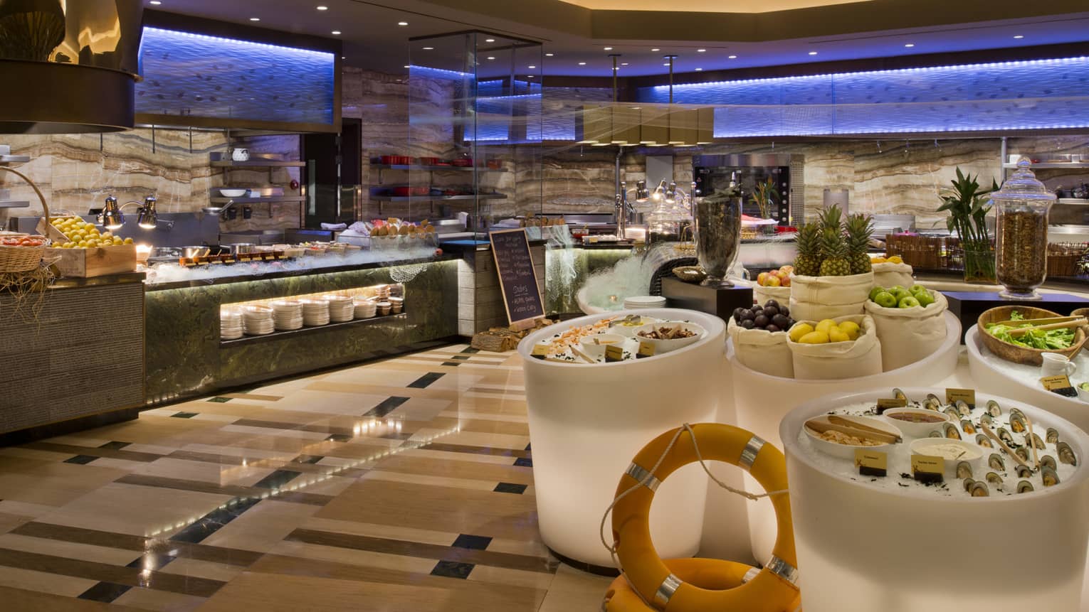 Bahrain Bay Kitchen buffet stations, large white bins of ice with seafood, fresh fruit, salad