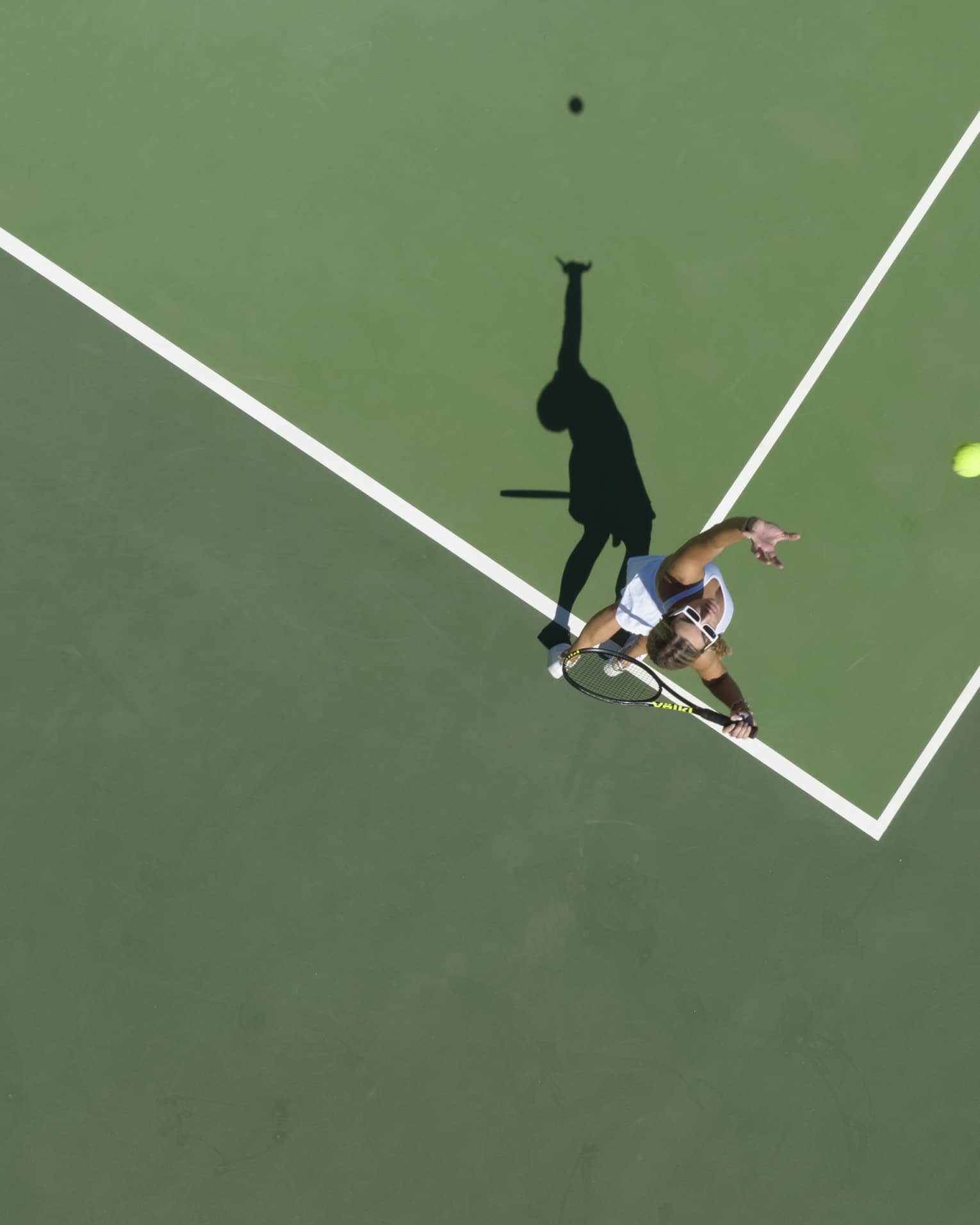 Aerial view of a tennis player mid serve