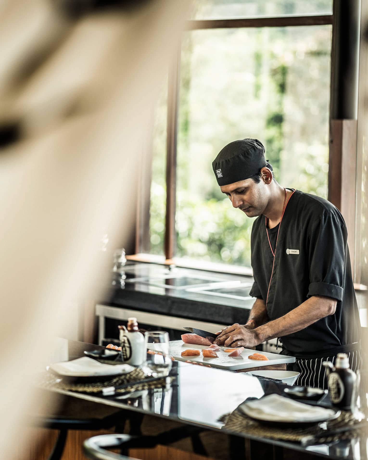KOI chef prepares sushi at counter in brightly lit room