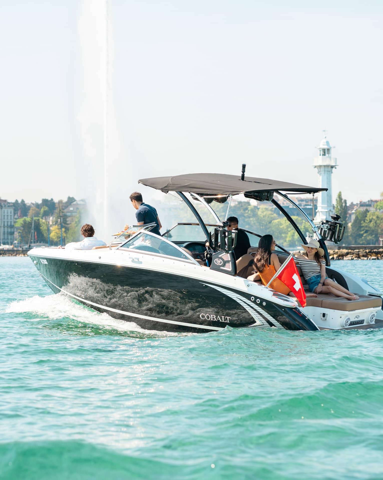 Group of friends in motorboat on Lake Geneva near the Jet d'Eau fountain