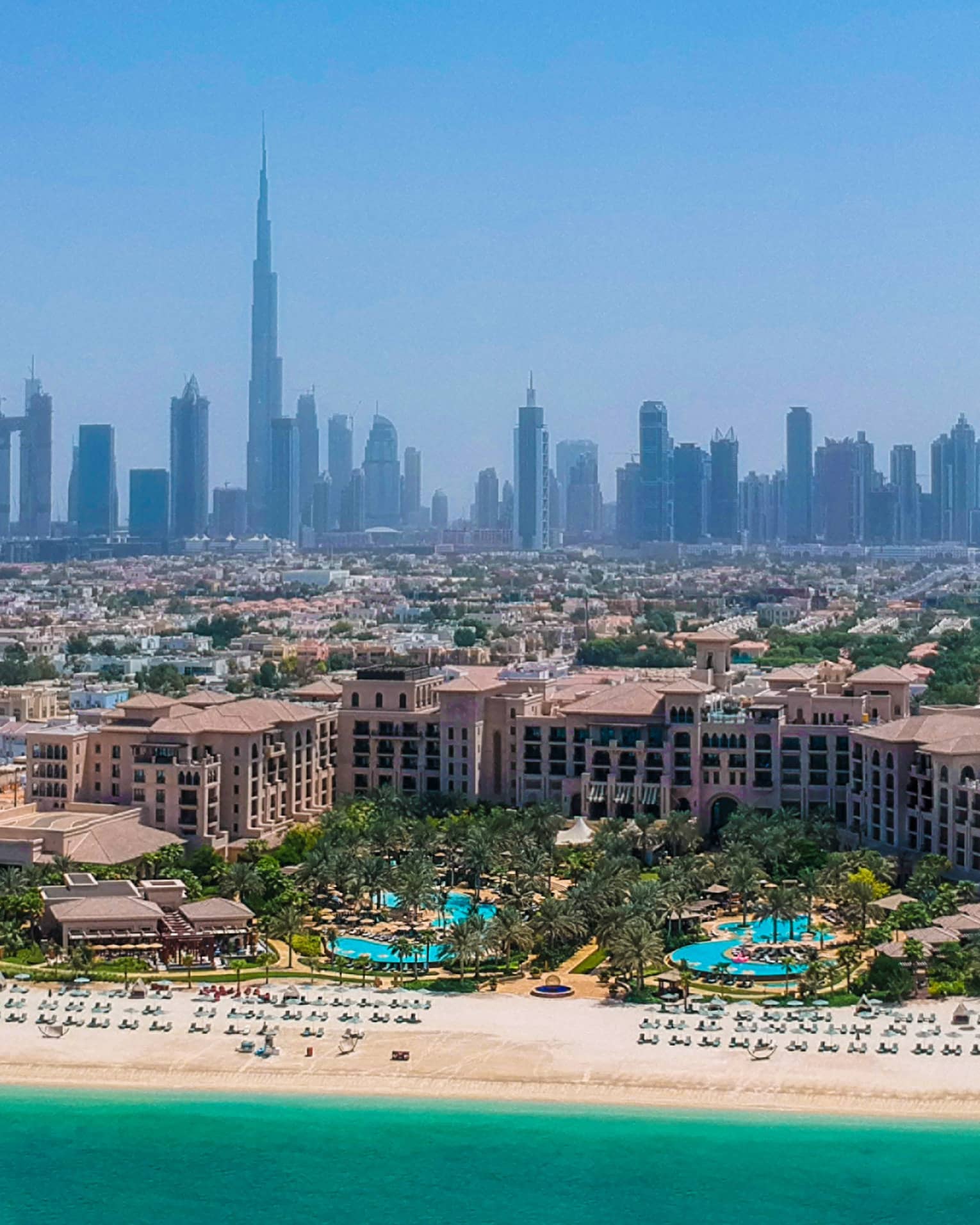 An aerial view of Jumeirah Beach in Dubai overlooking the blue waters and the large downtown area. 