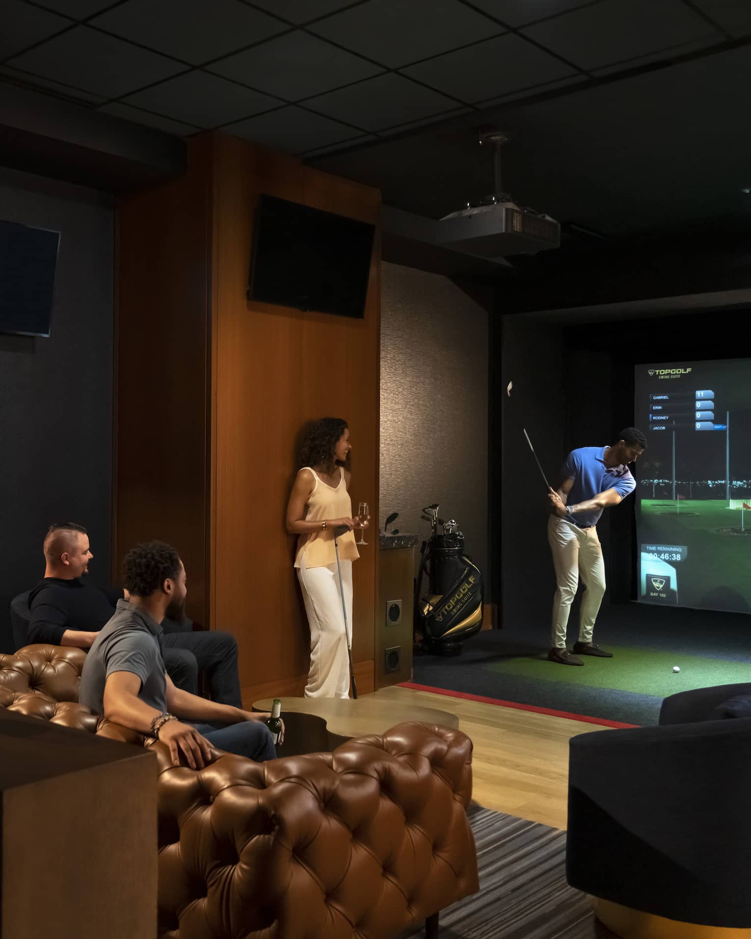 A group of people watching and playing a virtual golf game.