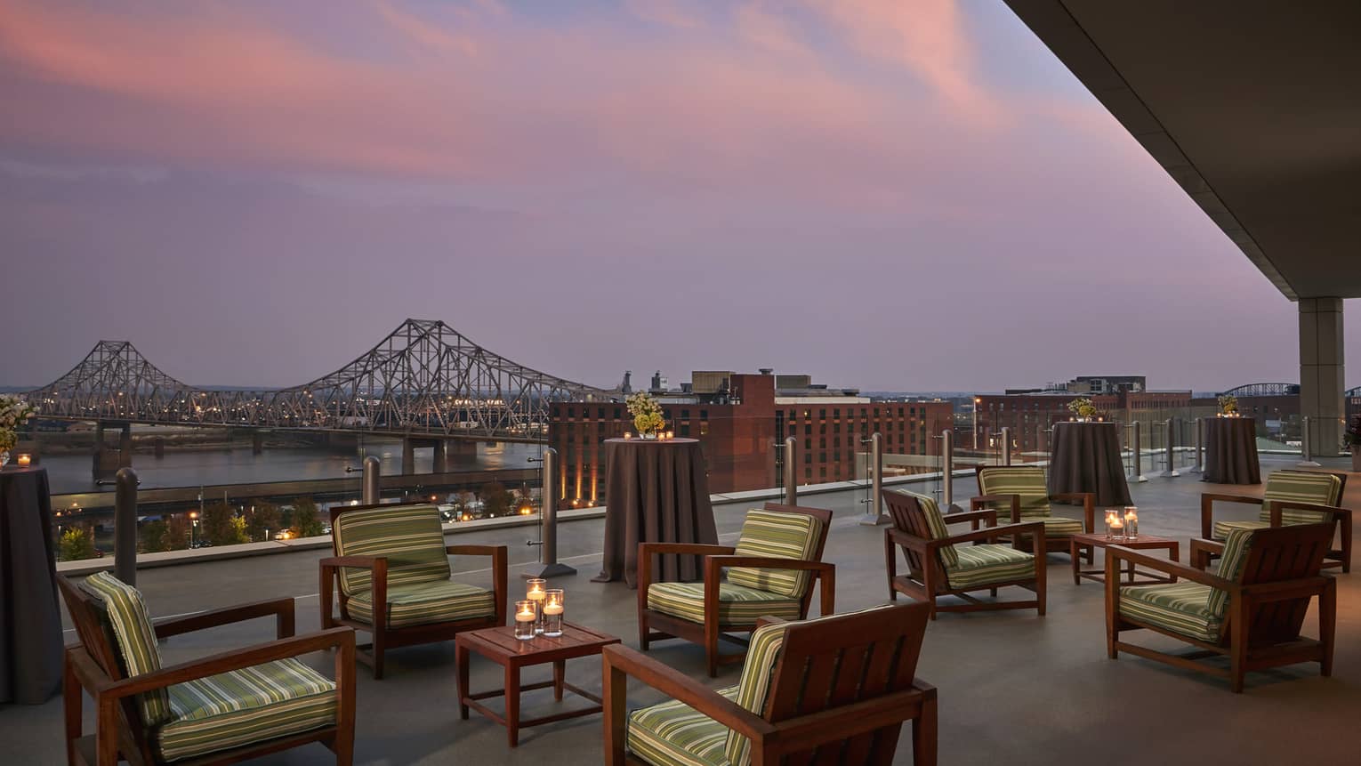 Rooftop patio lounge at sunset, bridge over river in background