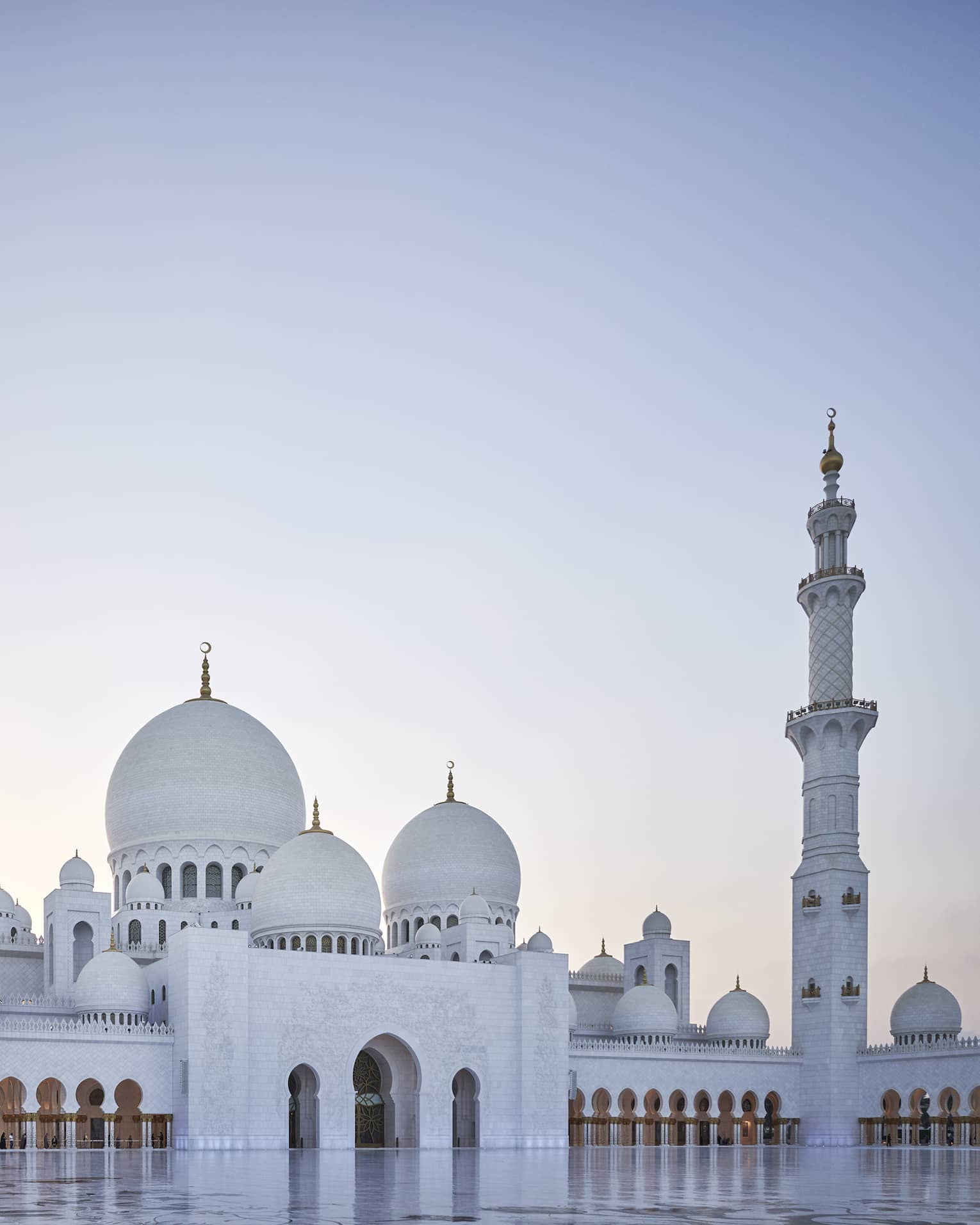 A large white mosque with two pillars made of marble.