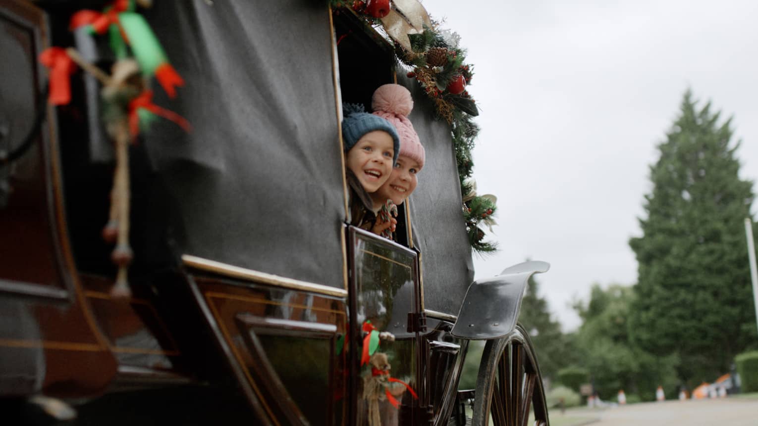 Two children looking out of a carriage.