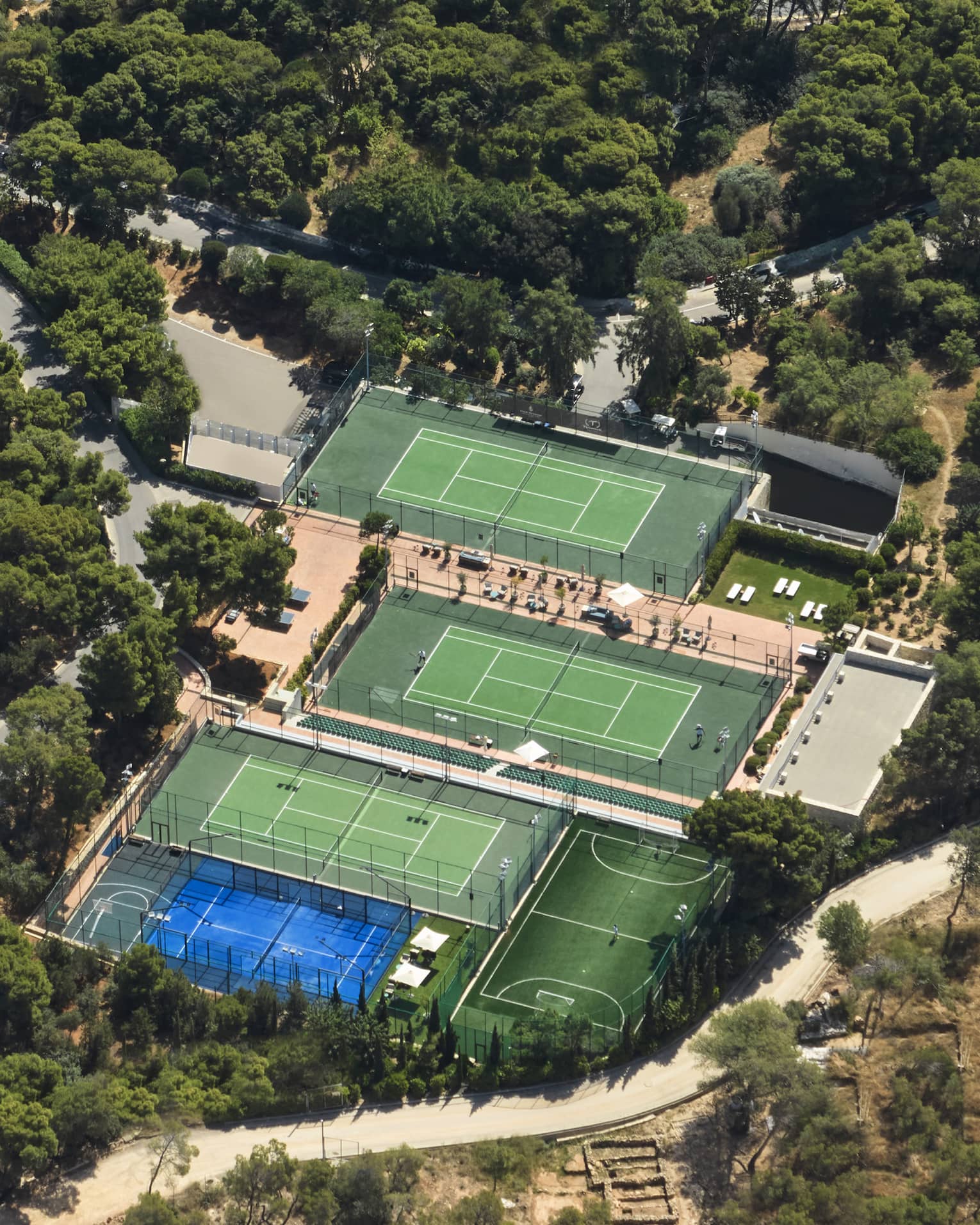 Aerial view of one padel and three tennis courts