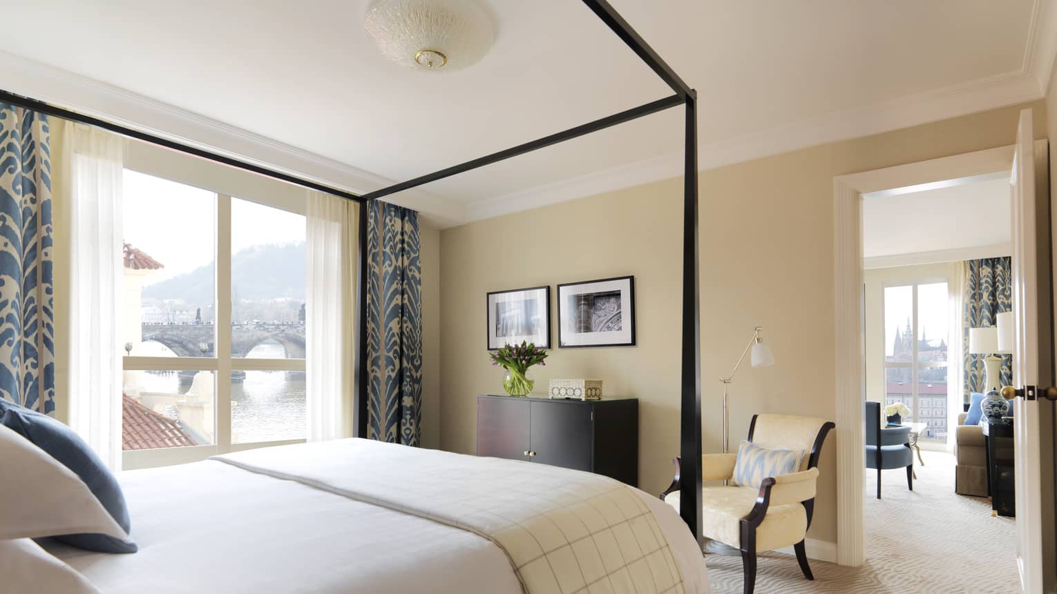 River Suite with modern ivory-coloured decor with blue accents on curtains, pillows, canopy bed frame