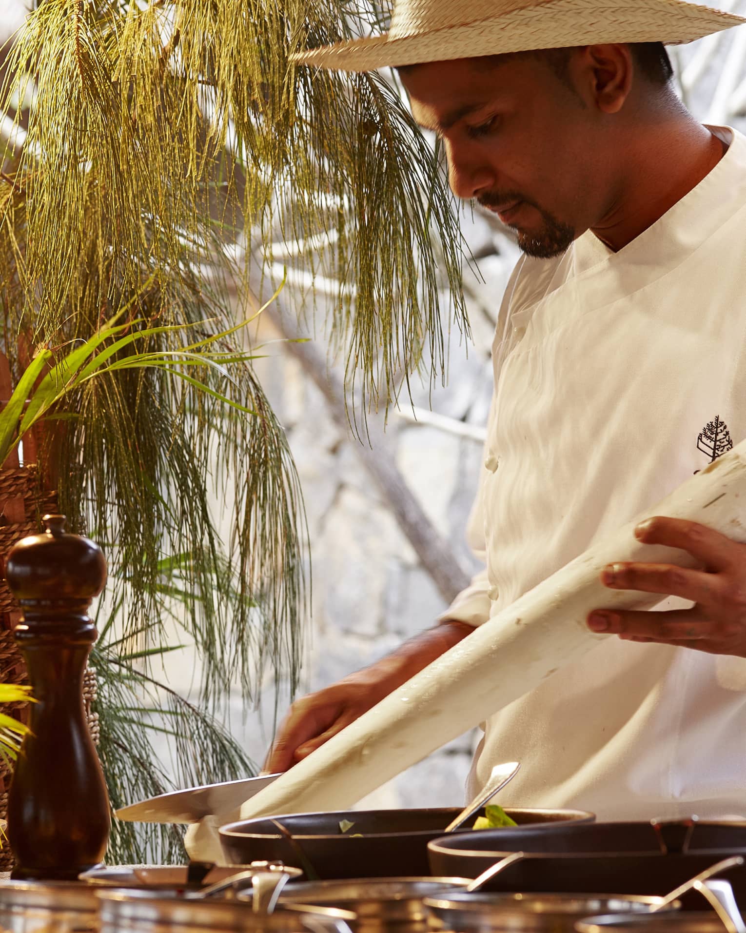 Zilwa Night, chef in white uniform carves long white stick by pepper mill
