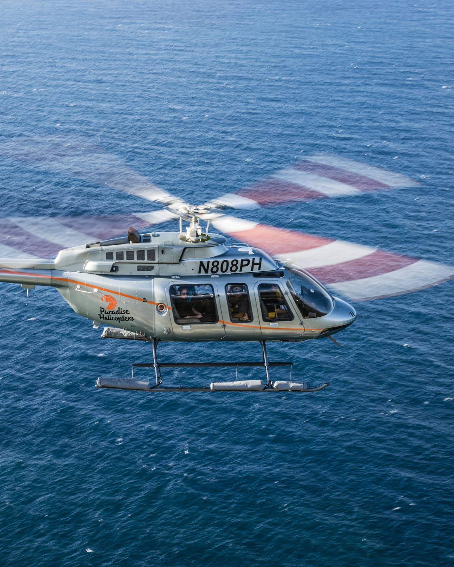 Helicopter flying over blue ocean