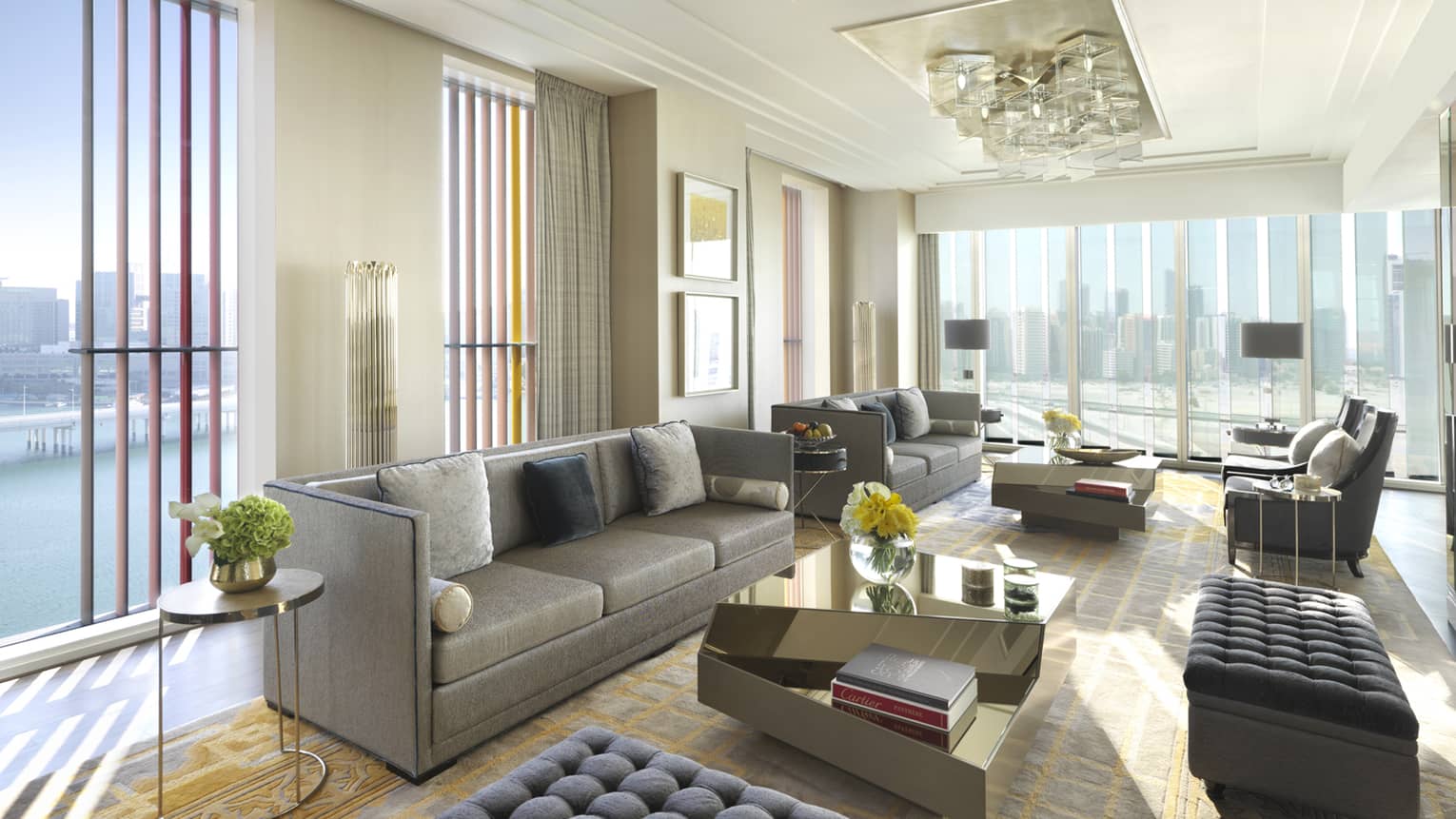 Presidential Suite with grey sofas and ottomans, floor-to-ceiling corner windows with sunny Gulf views