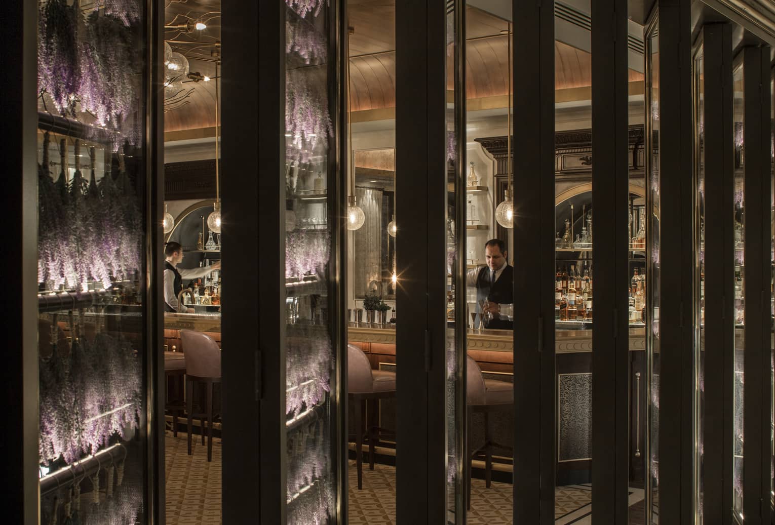 A view of a restaurant bar through several long rectangular pillars.