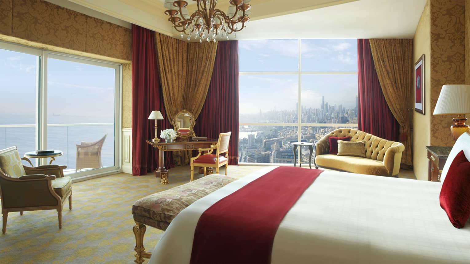 Royal Suite hotel room with red velvet pillow and blanket, chandelier with crystals, red-and-gold accent chairs