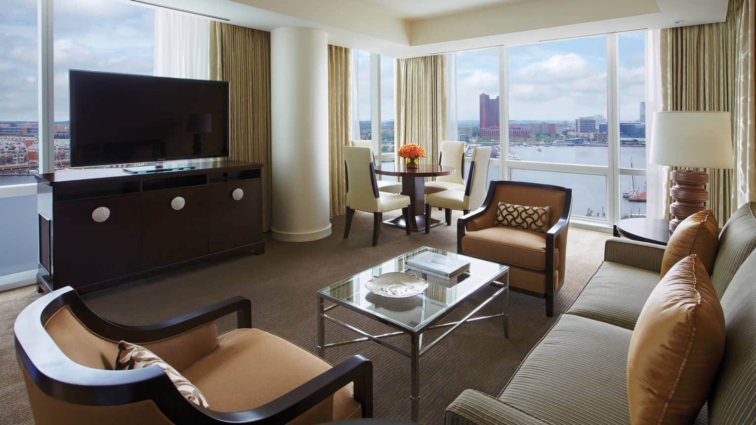 Harbour Suite loveseat, armchairs, dresser and TV in front of window overlooking water