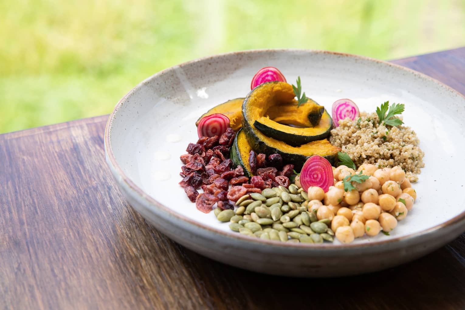 A bowl filled with a variety of grains and sliced mango. 