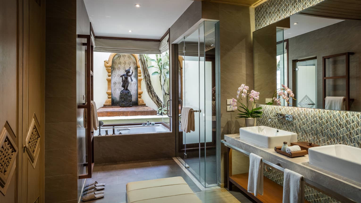 Garden Pavilion Room bathroom with double sink vanity, glass shower, tub under statue, monument