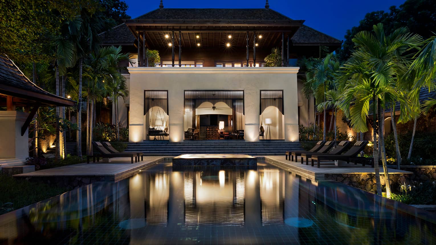 Large Four-Bedroom Residence Villa at night with lights, outdoor pool and palms 