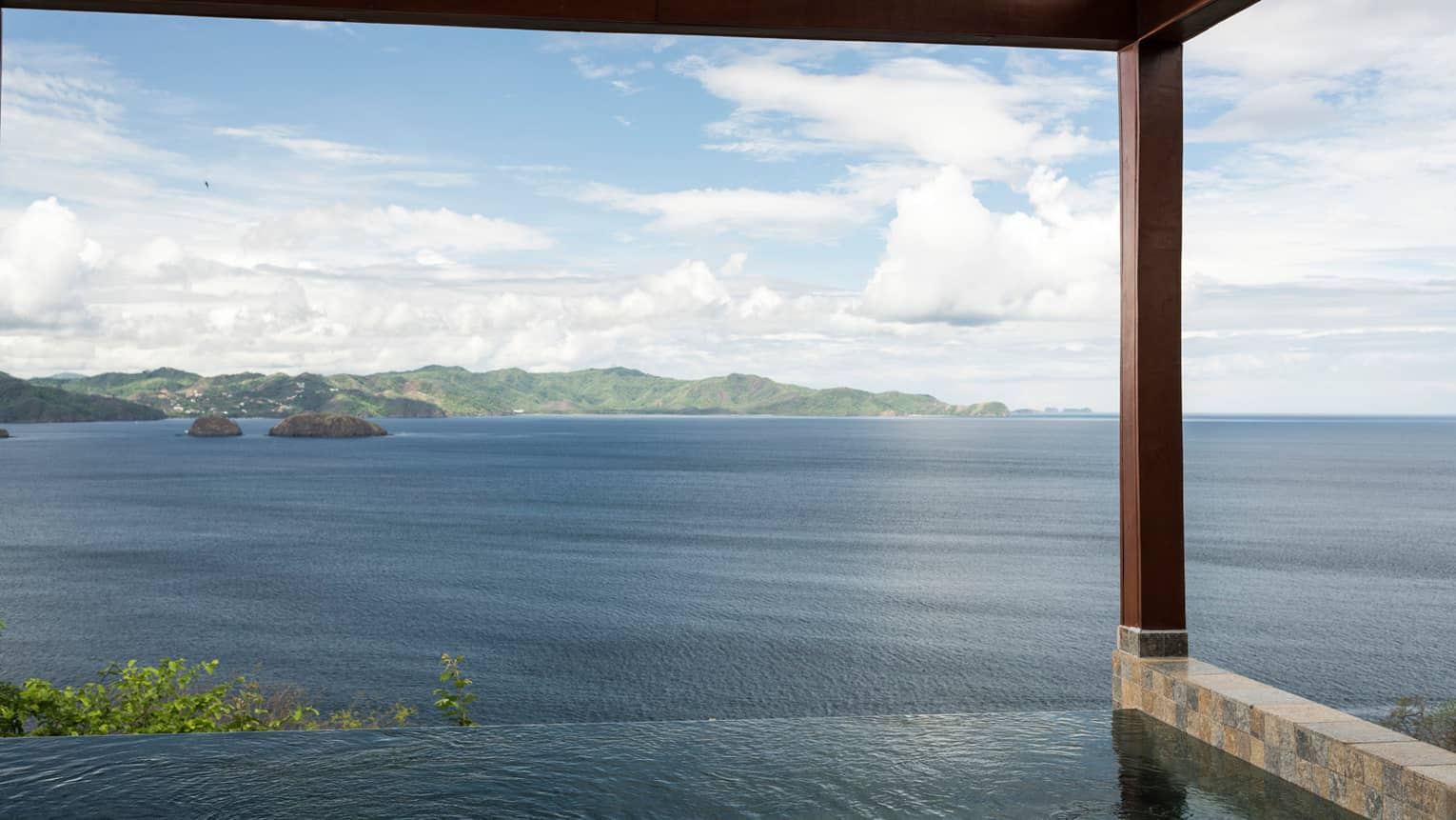 Canopy Plunge Pool Suite with sweeping views of ocean, mountain from edge of private infinity swimming pool
