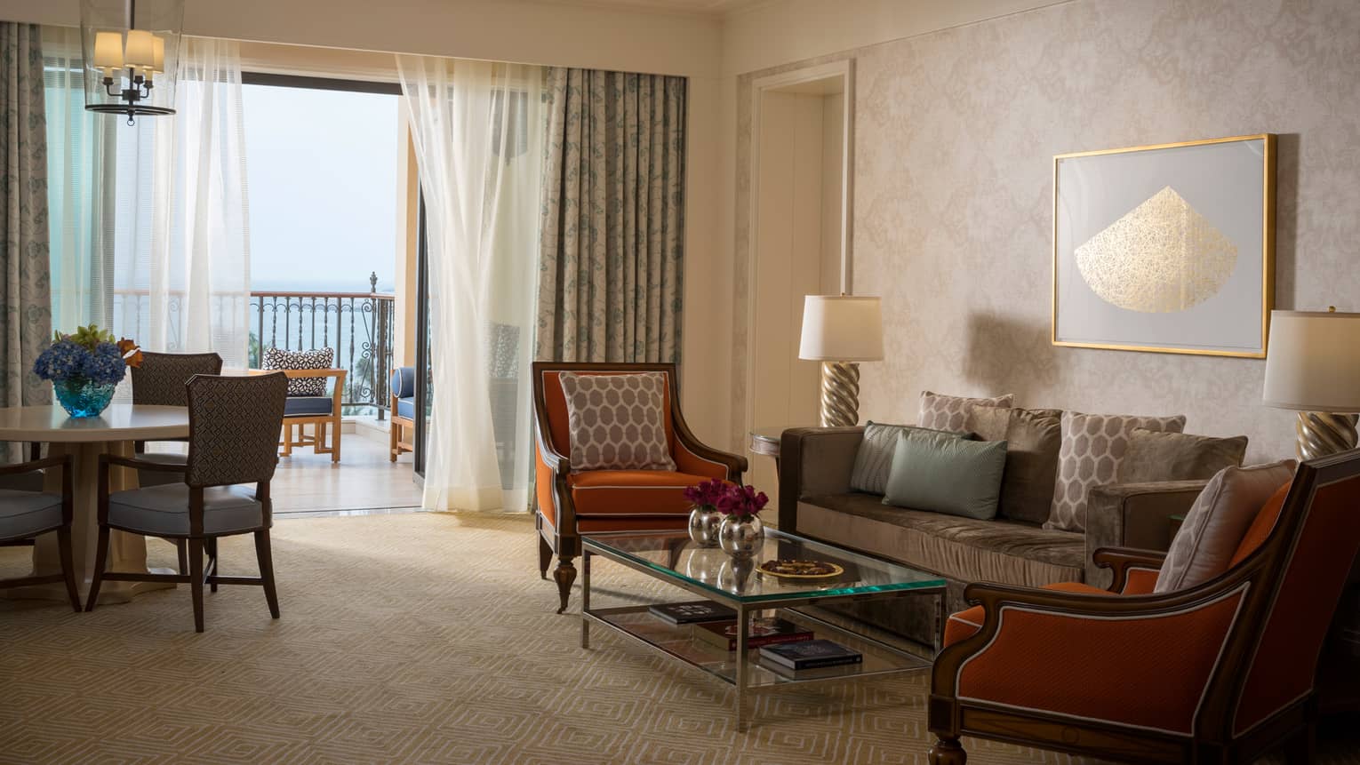 Jumeirah Sea-View Suite with large living space, orange and gold accents, white curtains