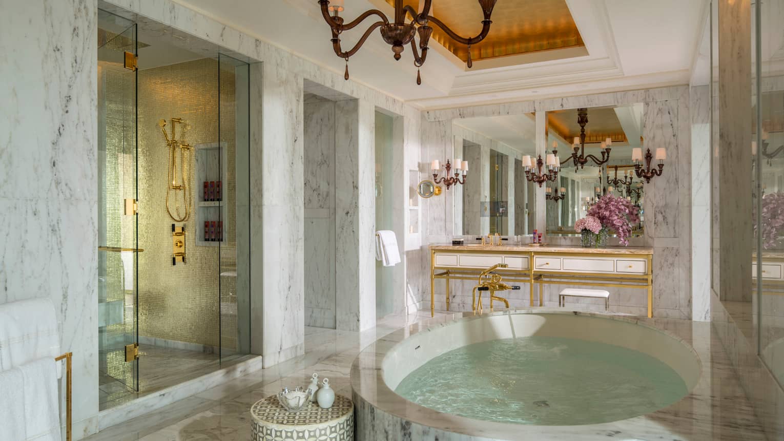 Royal Suite white marble master bathroom with circular spa tub, stand-up shower