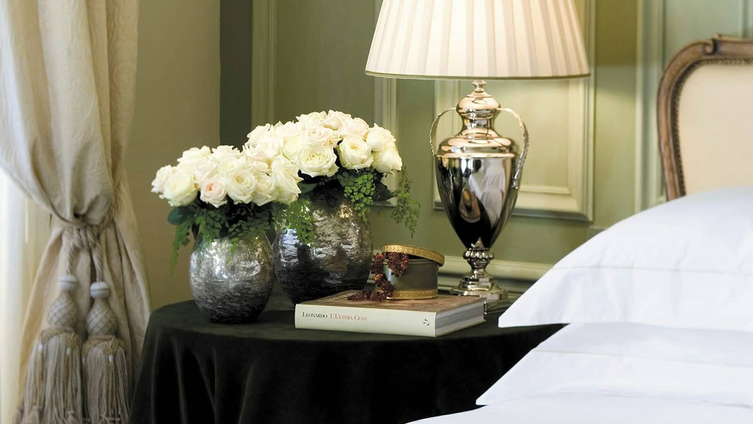 Superior Room silver lamp, vases with white roses, book on nightstand