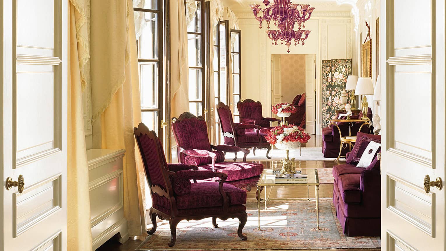 Sunny Presidential Suite purple velvet armchairs, loveseat under purple crystal chandelier