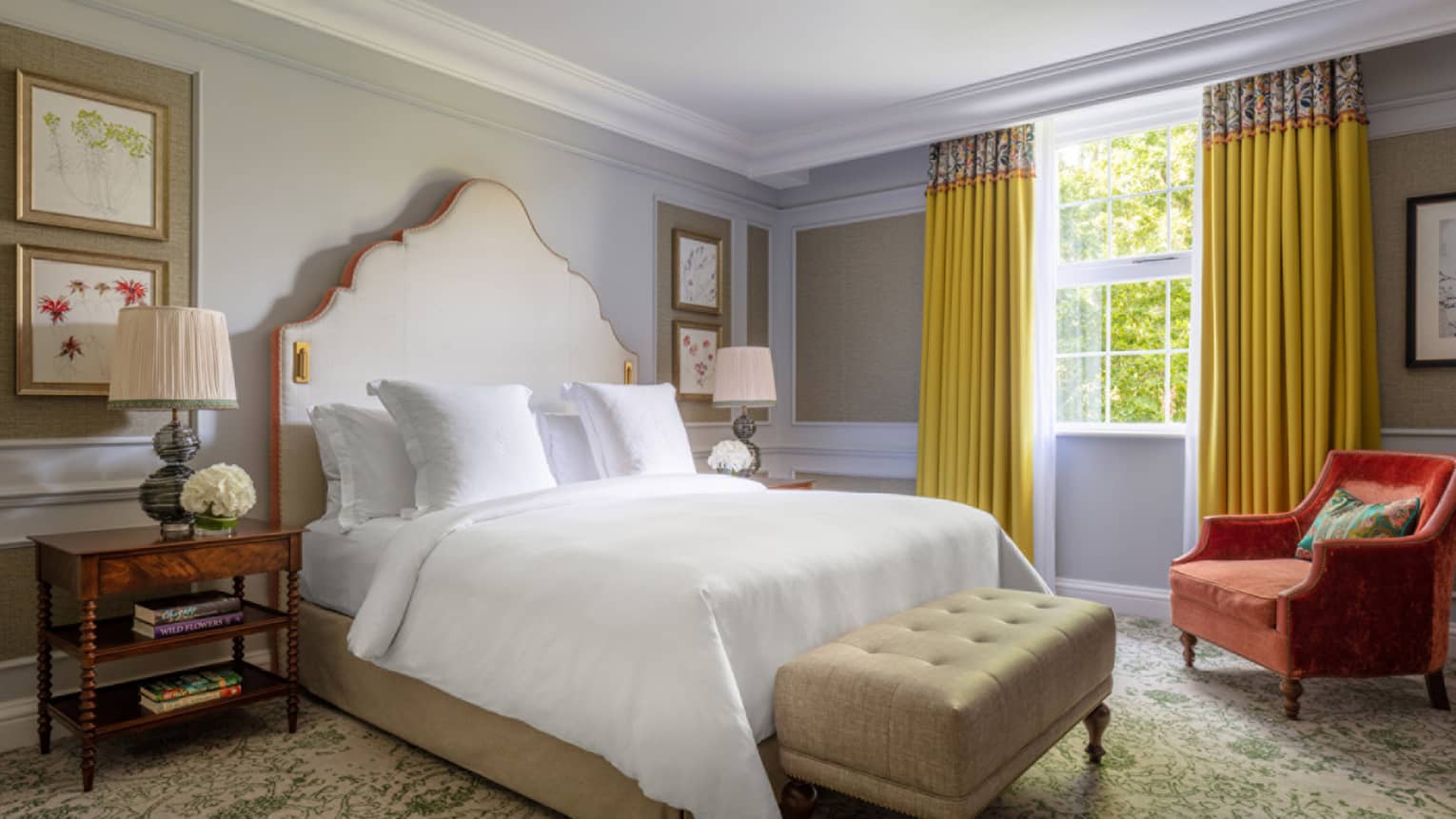 Guest room with Queen bed, white linens, paisley carpeting, cherry bed side table, red accent chair, turquoise walls, window with yellow drapes