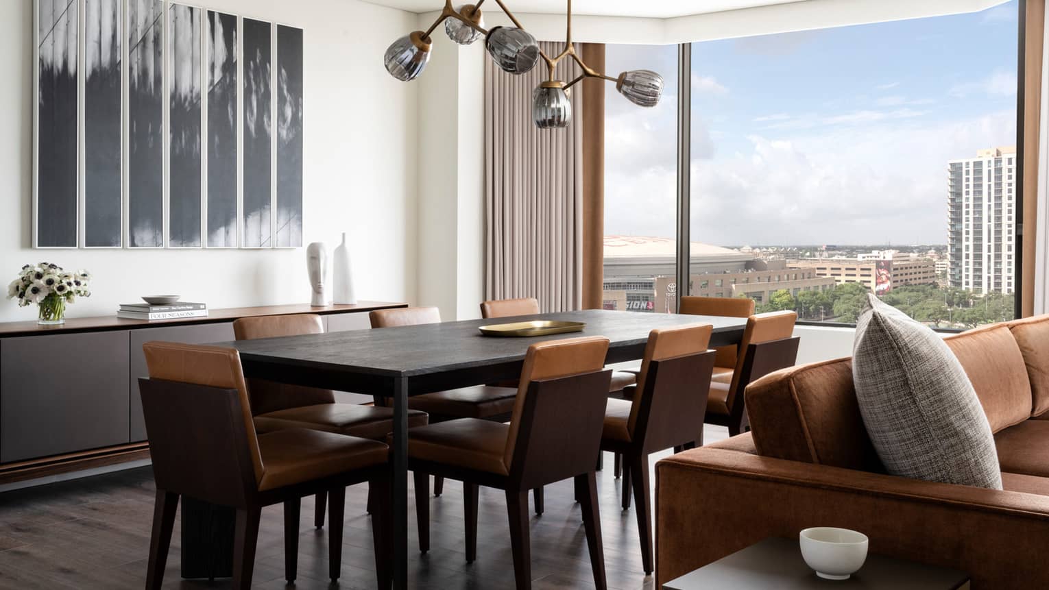 Dining room with table and eight chairs, modern hanging lamp, large window with city view