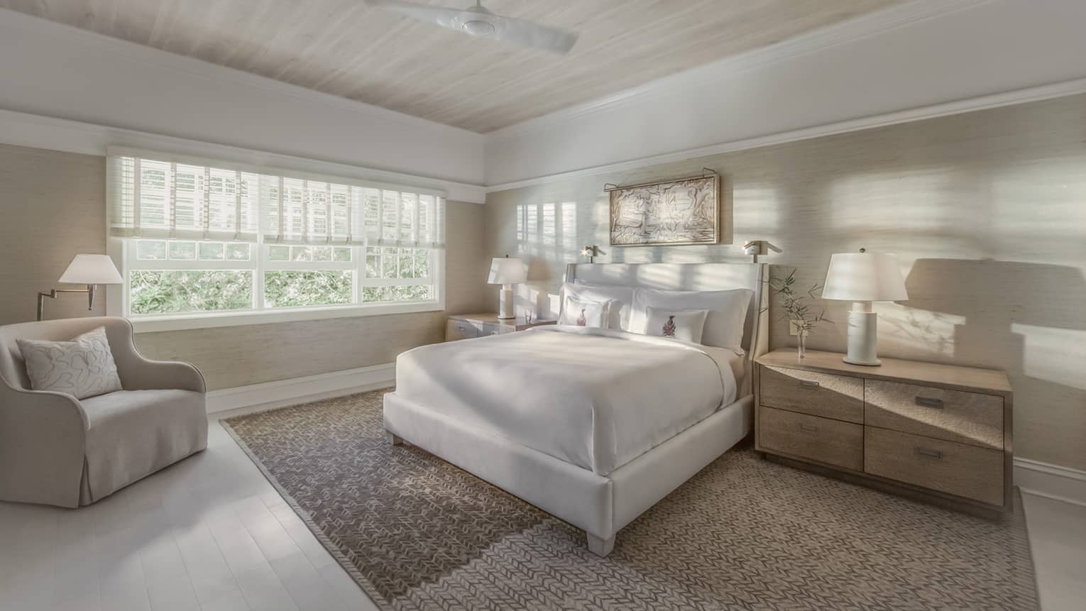 Sunlight and shadows shine through the window of a master suite bedroom