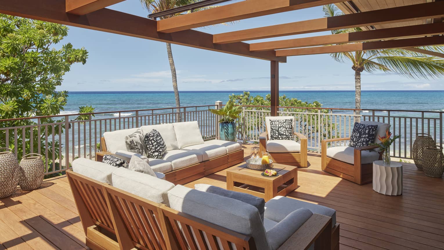 Wooden deck with two sofas and two arm chairs, ocean view