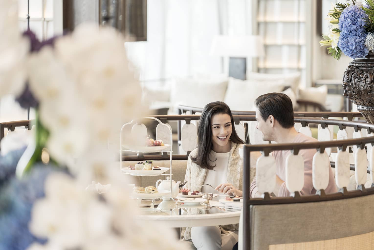 Smiling couple enjoys Afternoon Tea at the Lobby Lounge in round booth